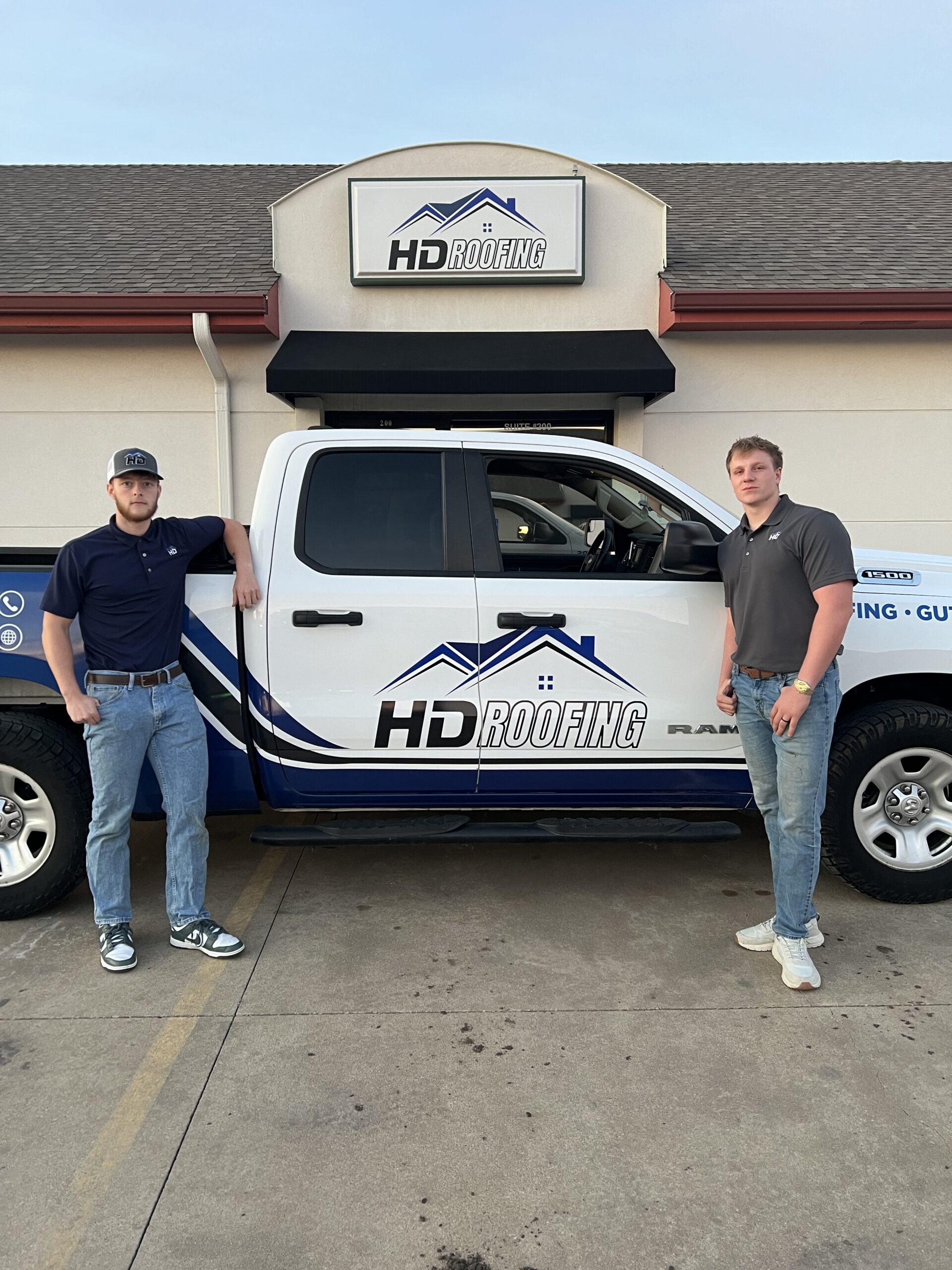 The HD Roofing team beside their branded truck